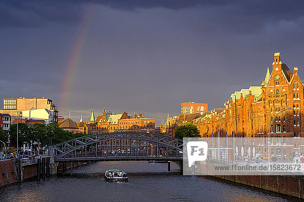 Germany  Hamburg  Rainbow over canal in Speicherstadt district at dusk