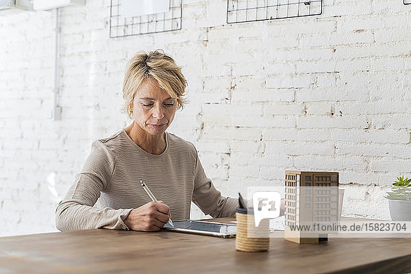 Mature woman working at desk in architectural office