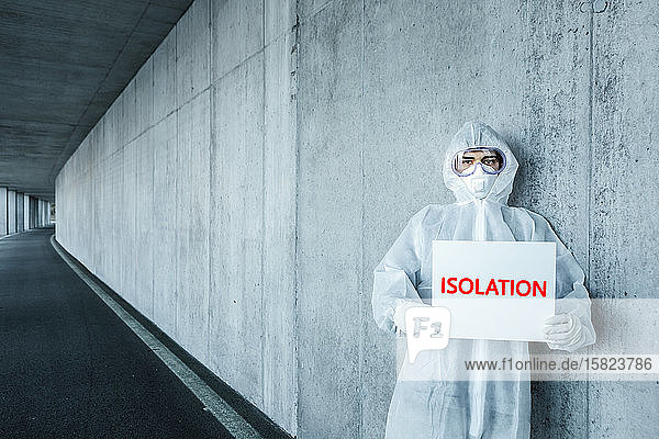 Porträt eines Mannes in Schutzkleidung mit einem Isolation -Schild