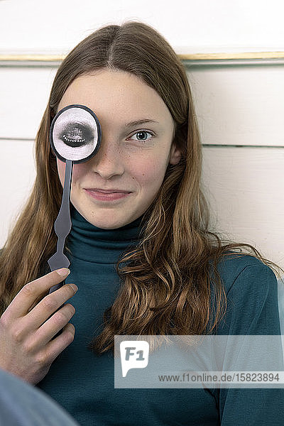 Portrait of smiling teenage girl with paper mask