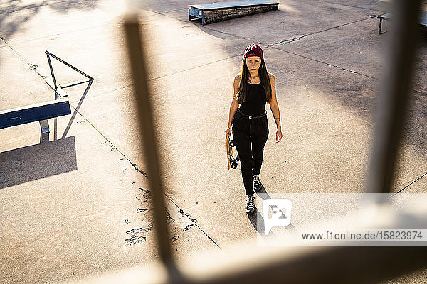 Junge Frau mit Skateboard im Skatepark