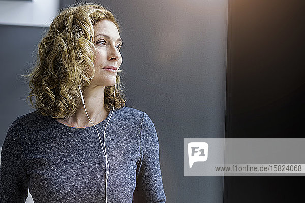 Porträt einer blonden Geschäftsfrau mit Kopfhörern im Büro