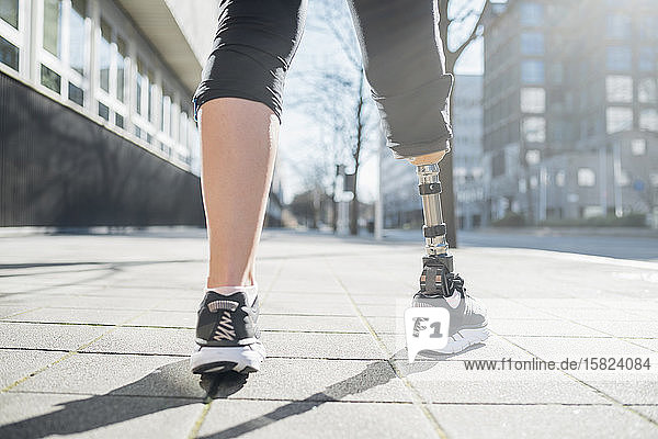 Nahaufnahme der Beine einer sportlichen Frau mit Beinprothese in der Stadt