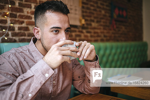 Man in a cafe drinking from cup