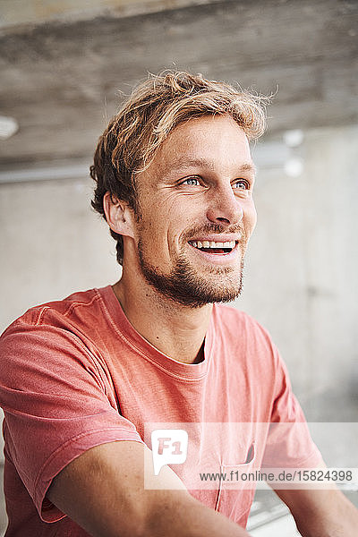 Porträt eines lachenden jungen Mannes mit rotem T-Shirt