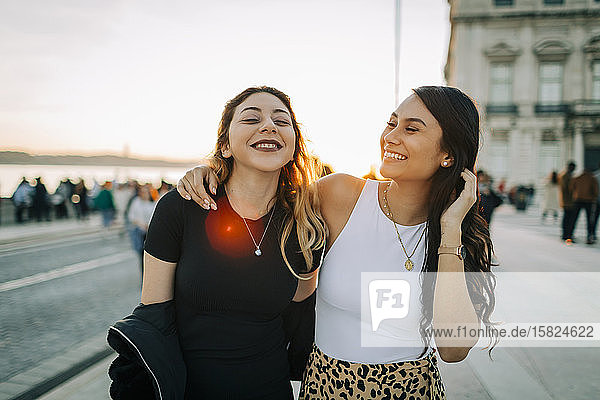 Portrait of two happy friends at sunset  Lisbon  Portugal