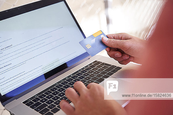 Man using laptop and holding credit card  close-up