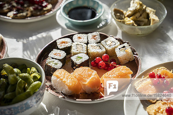 Spanien  Teller mit verzehrfertigem Sushi auf gedecktem Esstisch