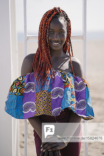 Portrait of smiling teenage girl with braids at the beach