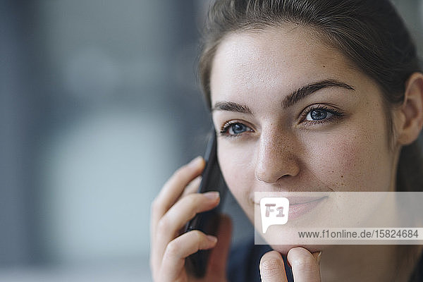 Porträt einer jungen Frau am Telefon