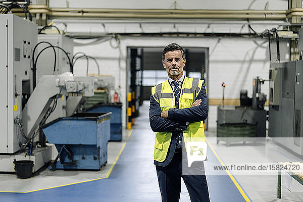 Portrait of a confident businessman wearing a reflective vest in a factory
