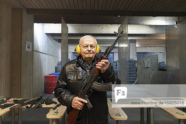 Porträt eines älteren Mannes mit einer Pistole auf dem Schießstand