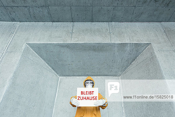 Porträt eines Mannes in Schutzkleidung mit einem Schild