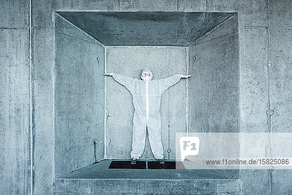 Mann in Schutzkleidung steht in einer Nische