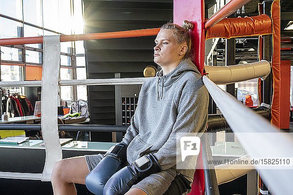 Boxerin in Turnhalle in der Ringecke sitzend