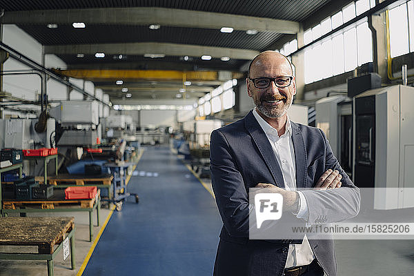 Porträt eines lächelnden Geschäftsmannes in einer Fabrik
