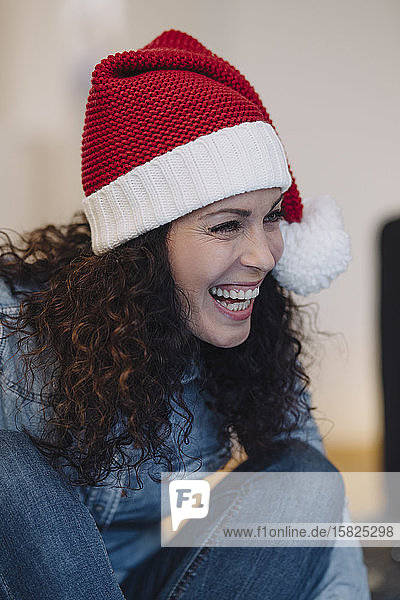 Porträt einer lachenden Frau mit Weihnachtsmannhut