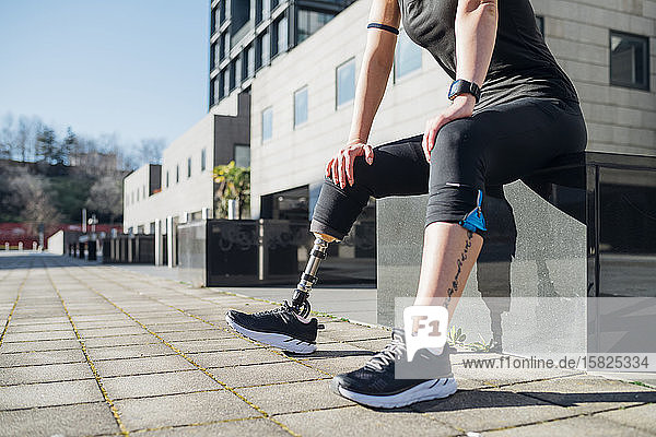 Unterer Abschnitt einer sportlichen jungen Frau mit Beinprothese in der Stadt