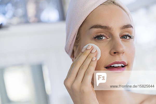 Woman using cleansing pad to wash face