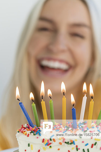Woman smiling behind birthday candles