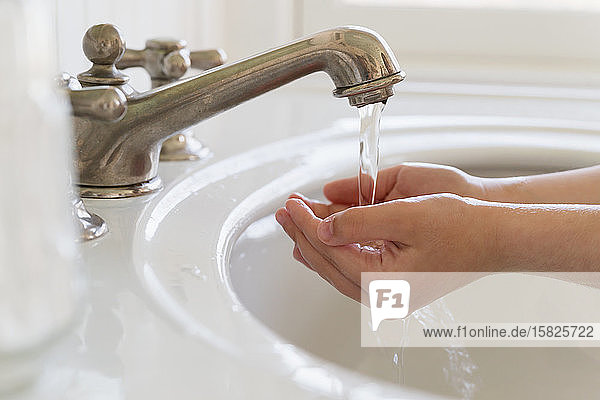 Close-upÂ of girl (6-7) washing hands
