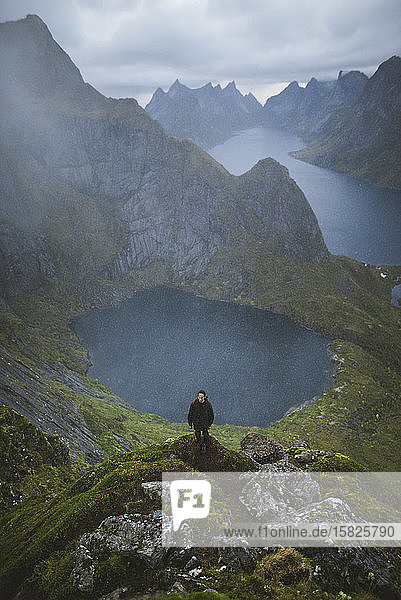 Norwegen  Lofoten  Reine  Mann auf dem Berg Reinebringen mit See und Fjord im Hintergrund