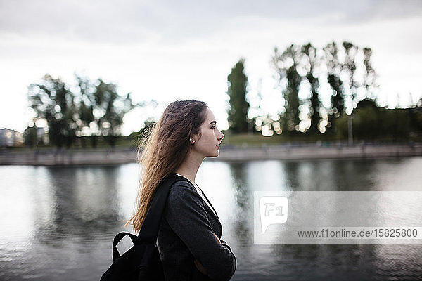 Frau geht bei bewölktem Wetter in der Nähe eines Sees spazieren