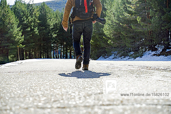 Photographer walking on a snowy mountain road