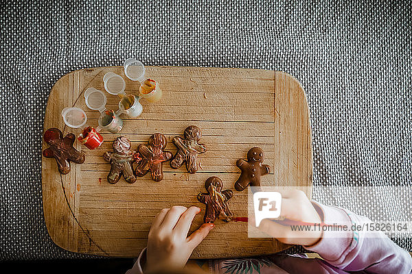 4-jähriges Mädchen malt Schokoladenlebkuchen Männer