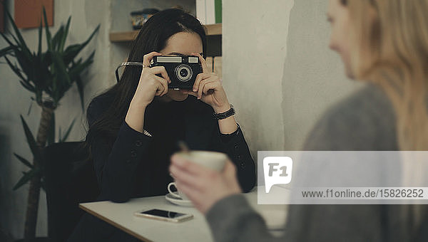 Frau macht ein Foto mit einer alten Kamera