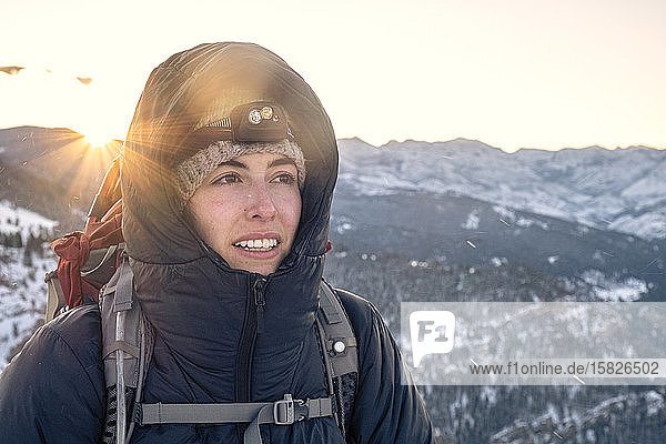 Young woman looking at view from summit of mountain in Montana sunrise