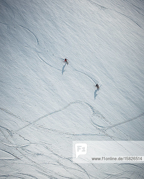 Zwei Männer beim Skifahren auf Schnee in Island aus dem Überkopfwinkel