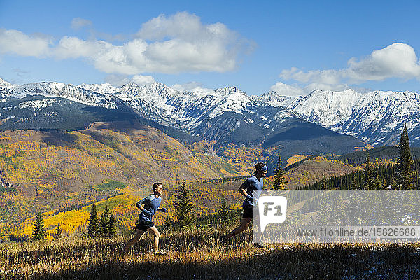 Men run ridge with Gore Range mountain views in Vail  Colorado
