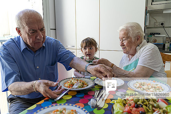 Großeltern essen mit der Enkelin in der Küche