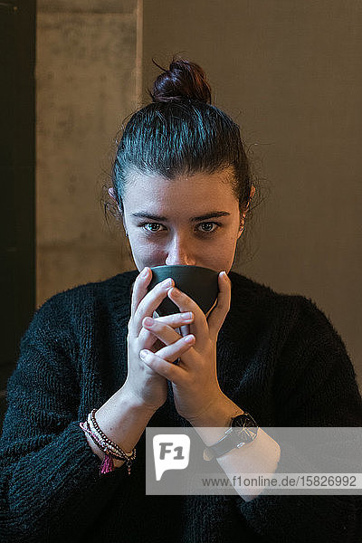 Junge Frau trinkt Kaffee in einem Kaffeehaus