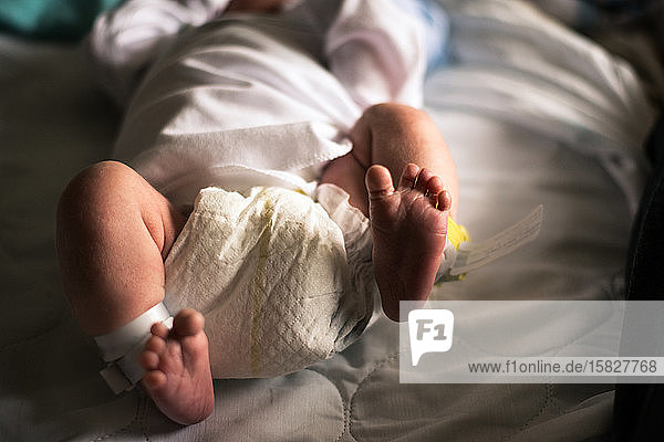 A newborn baby kicks his feet.