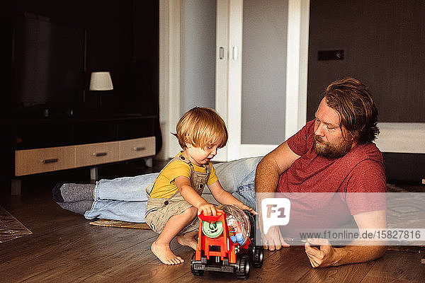 Vater und Sohn spielen zu Hause Auto
