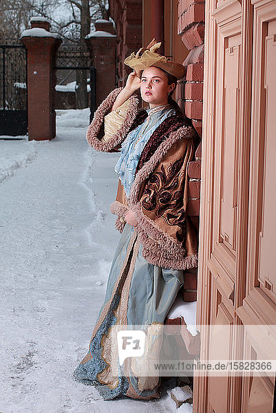 Schöne russische Frau in einem Vintage-Kleid. Russisches Dorf. Winter.