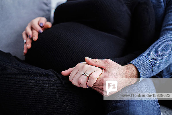 Paar erwartet eine Schwangerschaft in Erwartung eines Babys  das Händchen hält