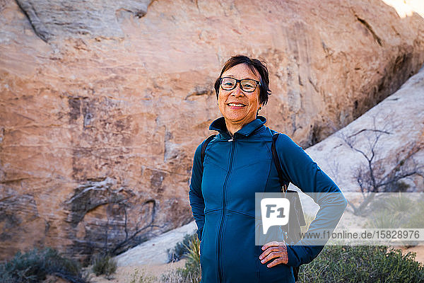 Portrait of Smiling Senior Asian Woman hiking in the desert landscape