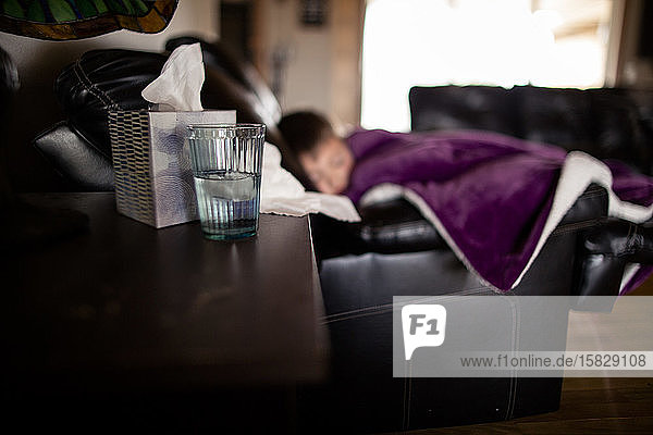 Seitenwinkelaufnahme eines verschwommenen kranken Jungen auf der Couch