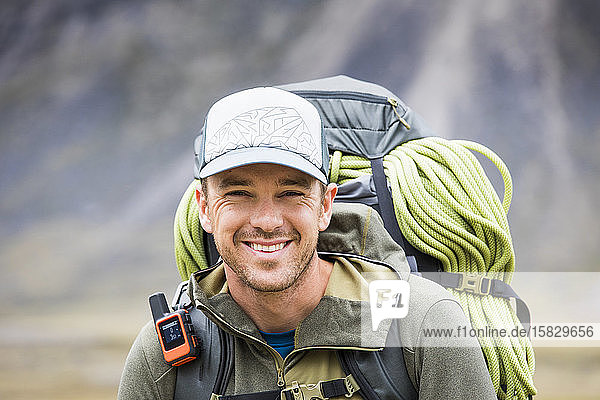 Portrait of climber wearing backpack  rope and GPS communication tool