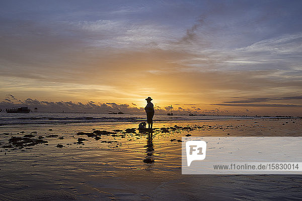 Old fisherman observes the sunrise at Redonda beach