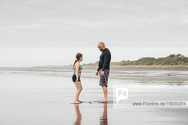 Vater und Tochter stehen am Strand