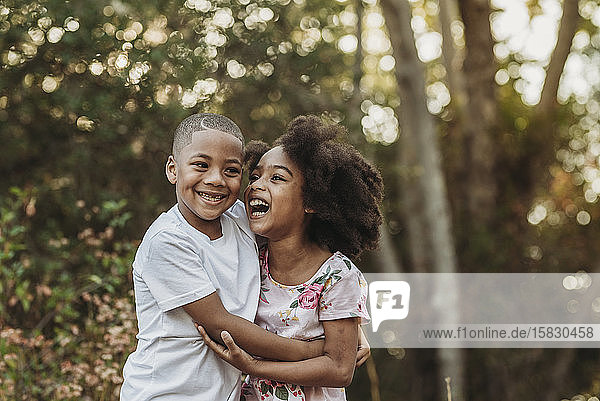 Close up portrait of brother and sister laughing at each other