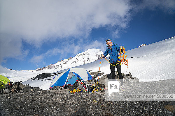 Eine Bergsteigerin wickelt ihr Seil vor ihrem Zelt im Basislager  Mt. Baker