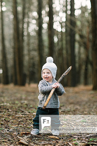 Toddler boy in woods with winter hat