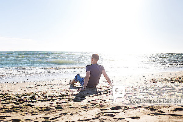 blonder Typ Tourist in Jeans  der Strand und Meer genießt