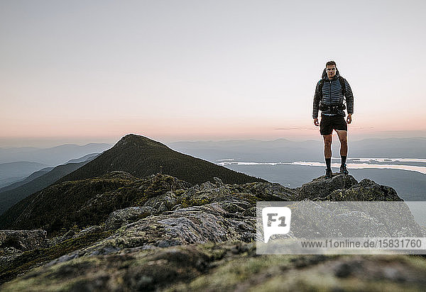 An athletic male hiker on the Appalachian Trail at sunset in Maine.