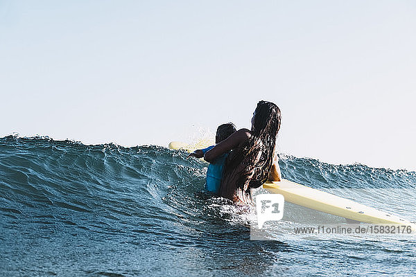 Eine Surfer-Mutter surft mit ihrem Sohn